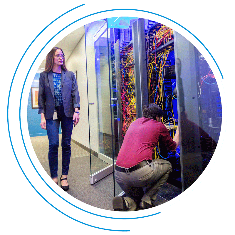 Woman surveys man fixing a data storage system