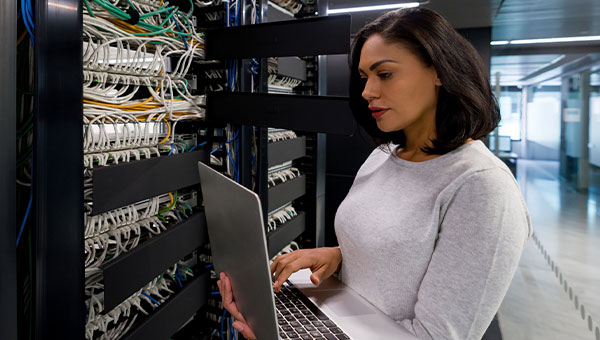 woman holding a laptop while checking on technology