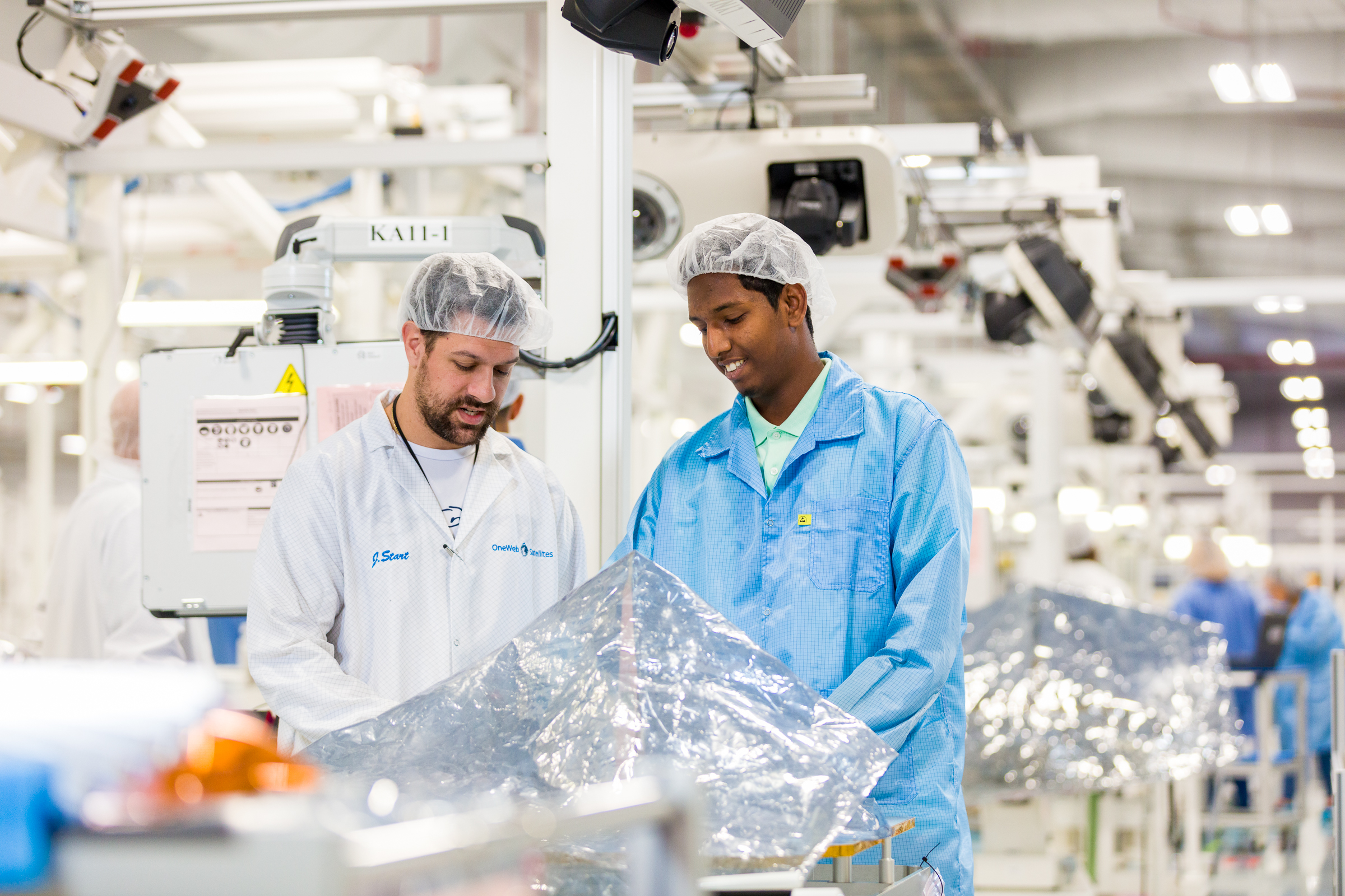 Two satellite engineers working in manufacturing factory Two satellite engineers working in manufacturing factory